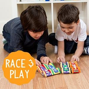 Two young boys playing with painted wooden race cars on a wooden floor.