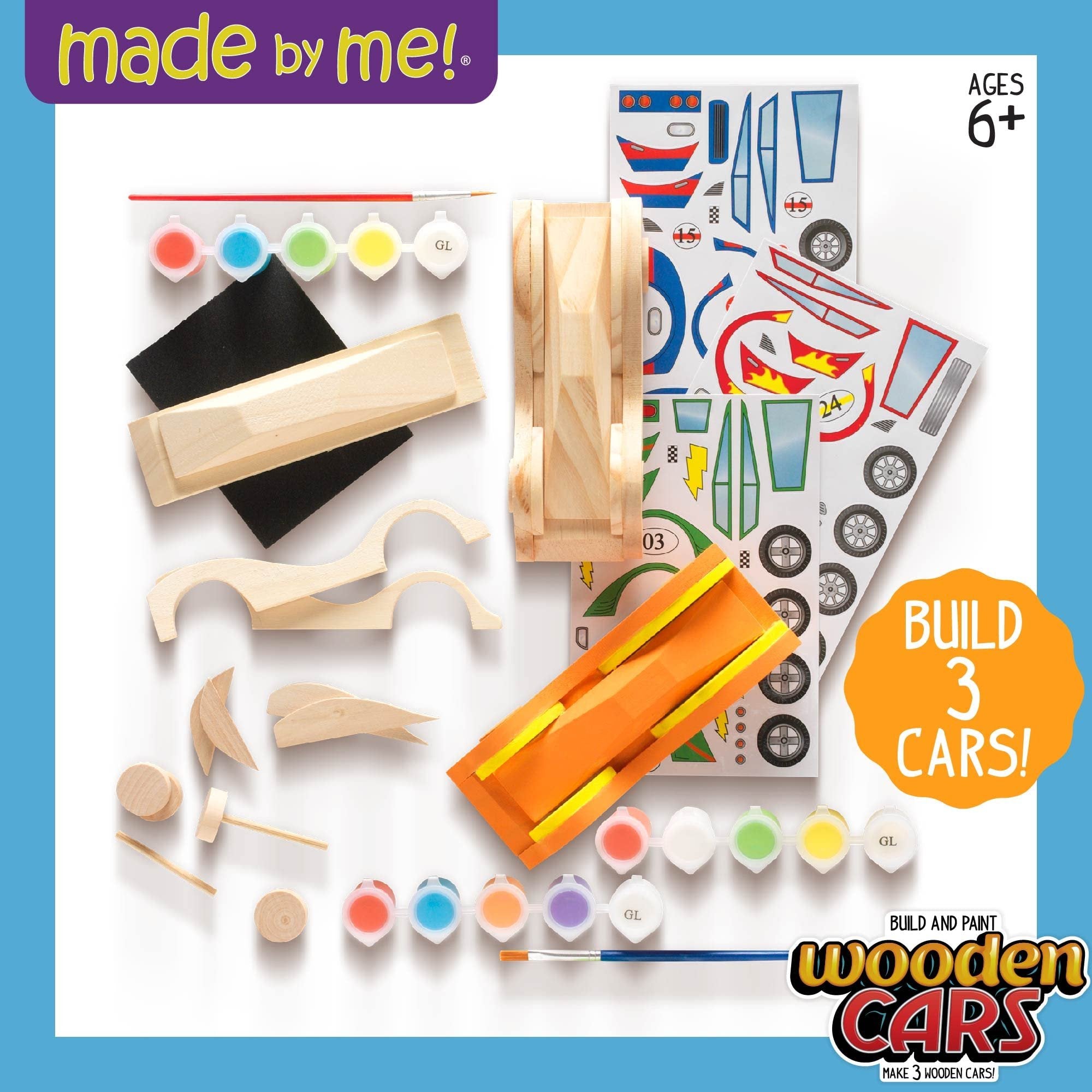 DIY wooden race car craft kit contents including wooden car parts, paint pots, brush, stickers, and sandpaper.