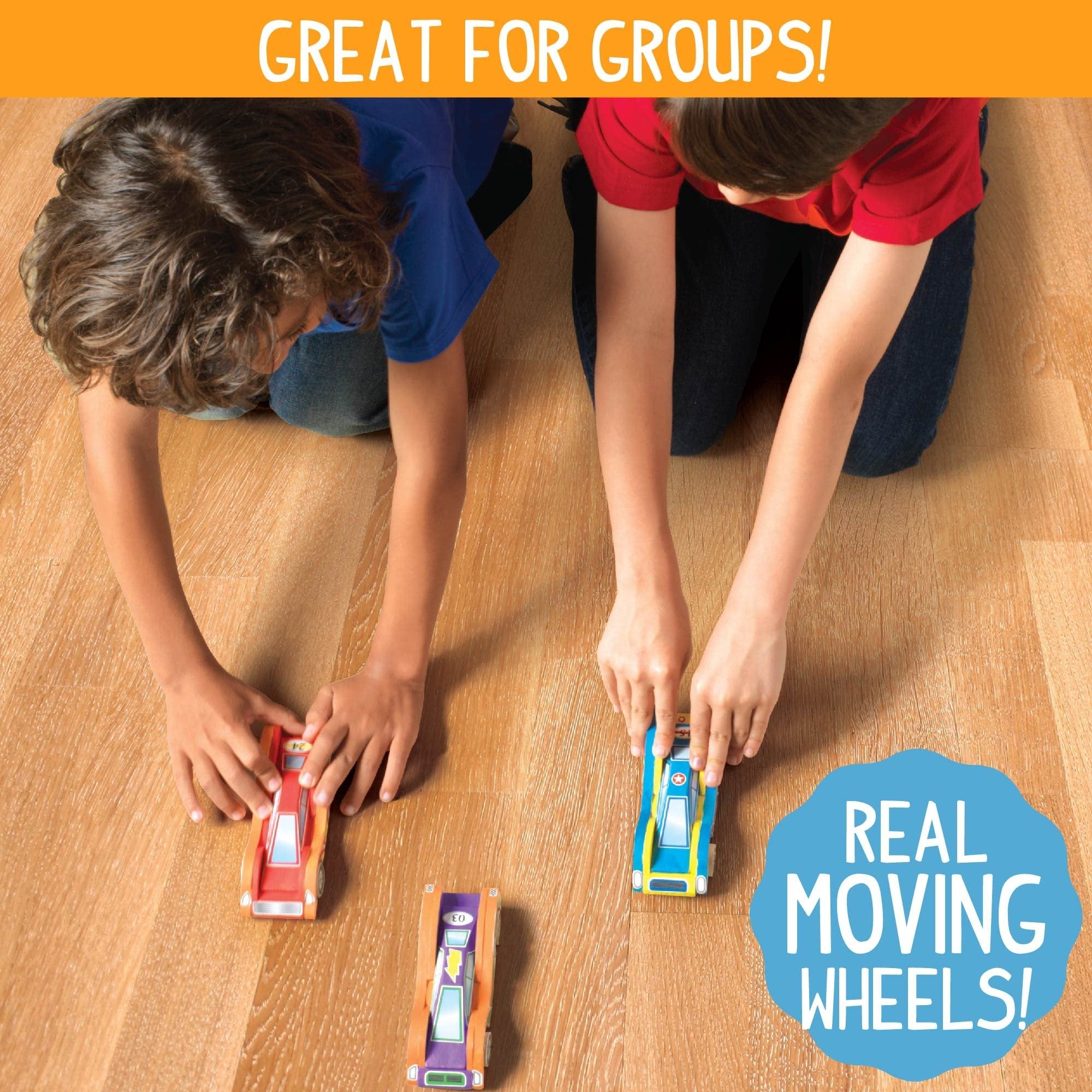 Two children playing with wooden race cars on a wooden floor, one car is red, one is blue and yellow, and one is purple and orange.