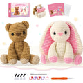 Crochet kit with finished bear and bunny figures, yarn, crochet hook, needle, stitch markers, and safety eyes.