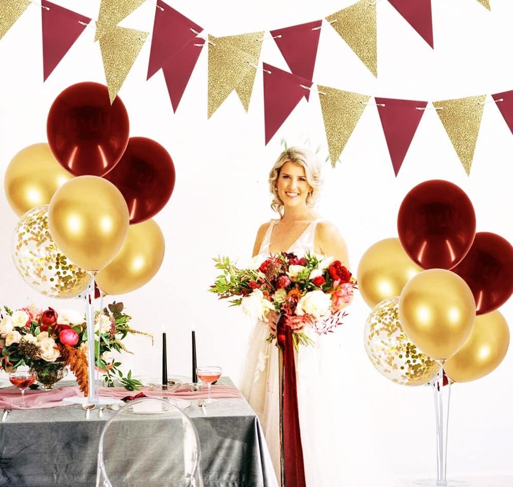 Woman holding a bouquet with burgundy and gold balloons and bunting in the background