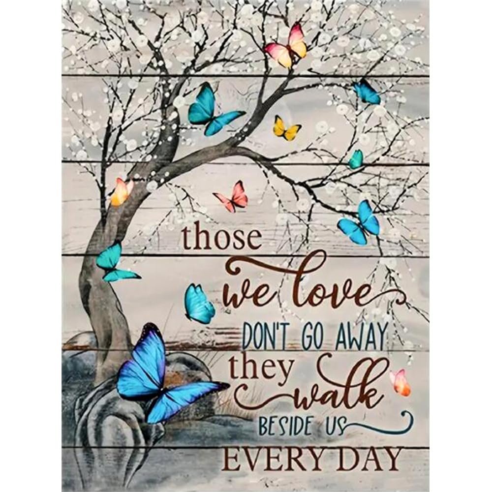 Butterfly diamond painting kit with quote 'Those we love don't go away they walk beside us every day' on a wooden background.