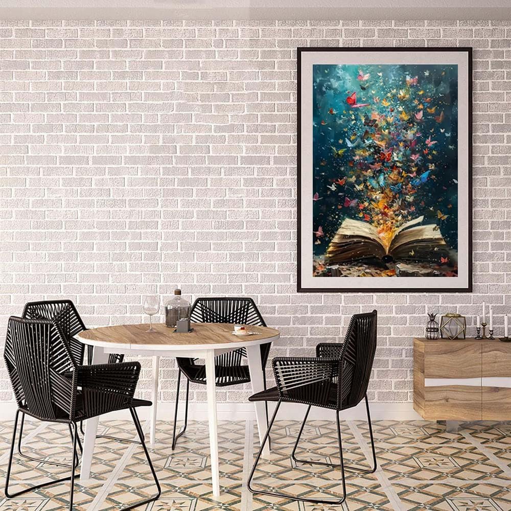 Diamond painting of an open book with colorful butterflies emerging, framed and hanging on a brick wall above a dining table.