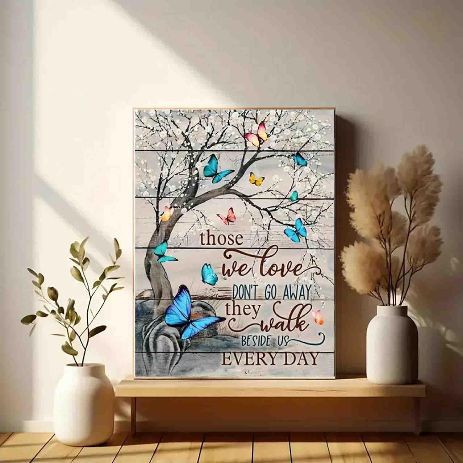 Butterfly tree art with inspirational quote on wood-plank background, displayed on a shelf with vases and plants.