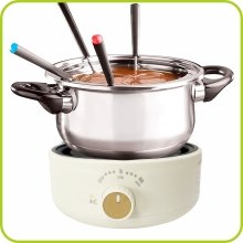 Chocolate fondue pot with melting pot and fondue forks on a hot plate