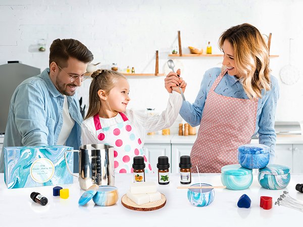 Family making candles together in a kitchen, with candle making supplies laid out on a counter.