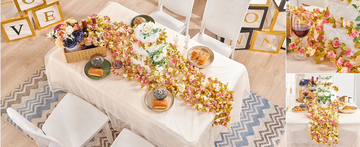 Champagne artificial rose vine garland draped over a table with a cake, pastries, and wine.