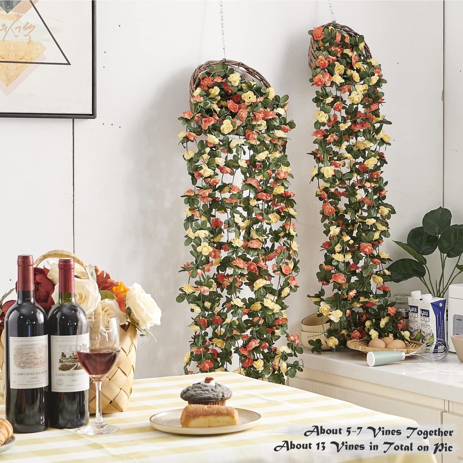 Champagne artificial rose vines with green leaves hanging from baskets, set on a table with wine and pastries.