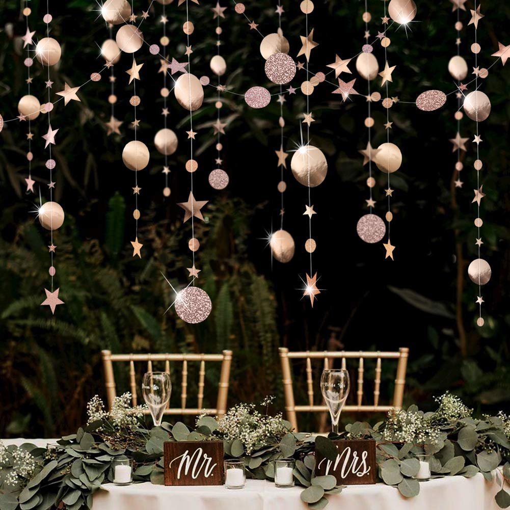 Champagne gold star and circle garlands hanging over a decorated table with Mr. and Mrs. signs