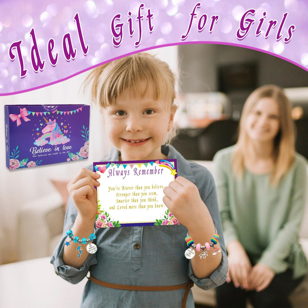 Young girl holding a card and showing off a charm bracelet, with a woman blurred in the background.