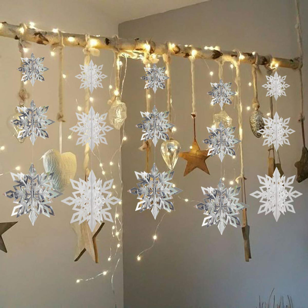 White and silver 3D paper snowflake ornaments hanging from a branch with fairy lights