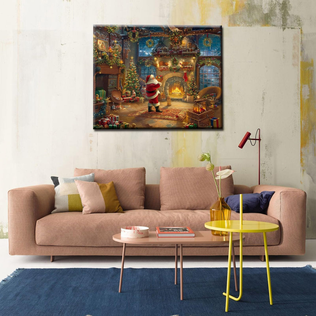 Christmas scene painting of Santa by a fireplace with Christmas trees and gifts, displayed above a sofa.