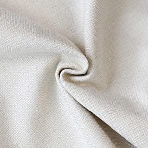 Close-up of textured beige linen fabric, showing weave detail and a central swirl.