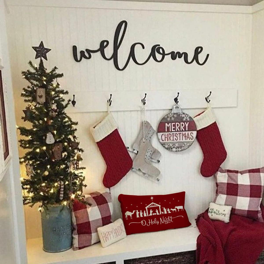Christmas scene with a decorated tree, stockings, and pillows, featuring a red lumbar pillow with a nativity silhouette and 'O Holy Night' text.