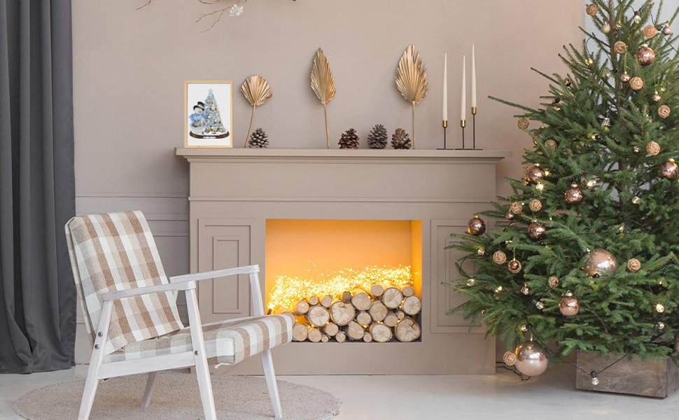 Christmas tree with ornaments and lights next to a fireplace with a diamond painting on the mantel