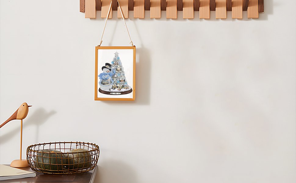 Framed 5D diamond painting of a snowman and Christmas tree hanging on a wall