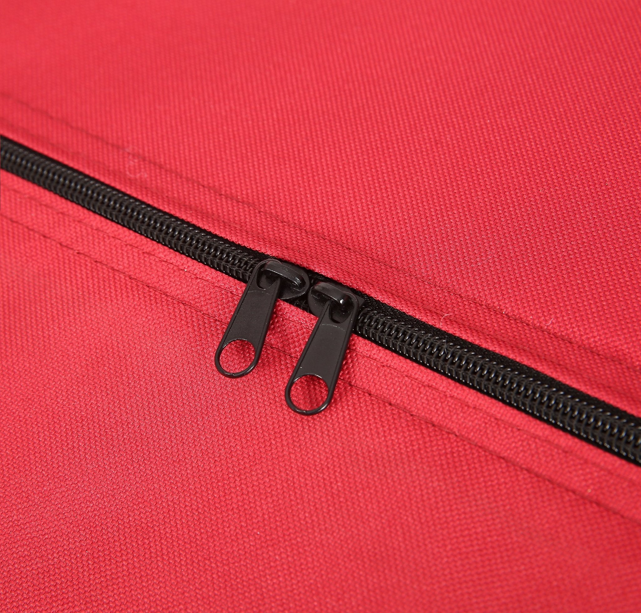 Close-up of a red Christmas tree storage bag showing a black dual zipper with two pull tabs.
