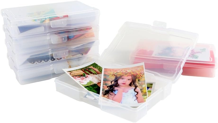 Stack of clear plastic photo storage boxes with snap-tight lids, one open box shows photos of children inside.