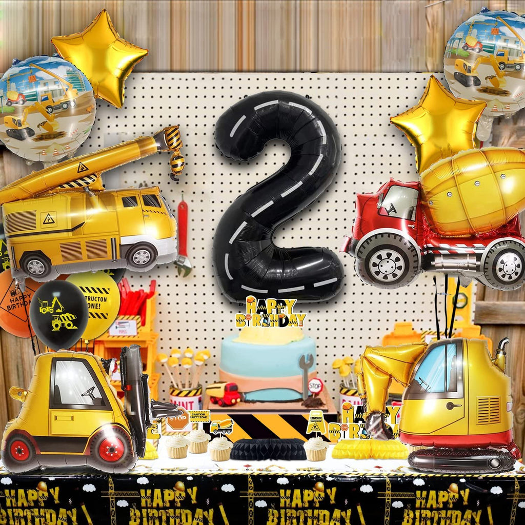 Construction-themed 2nd birthday party decorations including balloons, cake, cupcakes, and a table cloth.