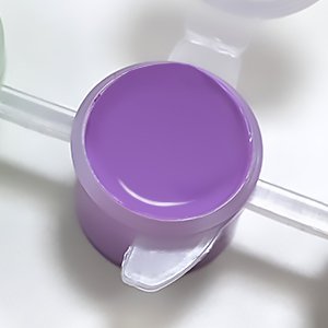 Close-up of a purple acrylic paint pot from a painting kit, with a plastic holder visible.
