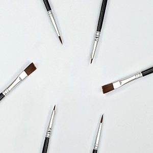 Set of seven paint brushes arranged in a circle on a white background, showing various sizes and shapes.