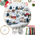 Embroidery kit with a winter village scene on an 8-inch hoop, showing houses and trees covered in snow, with floss and instructions.