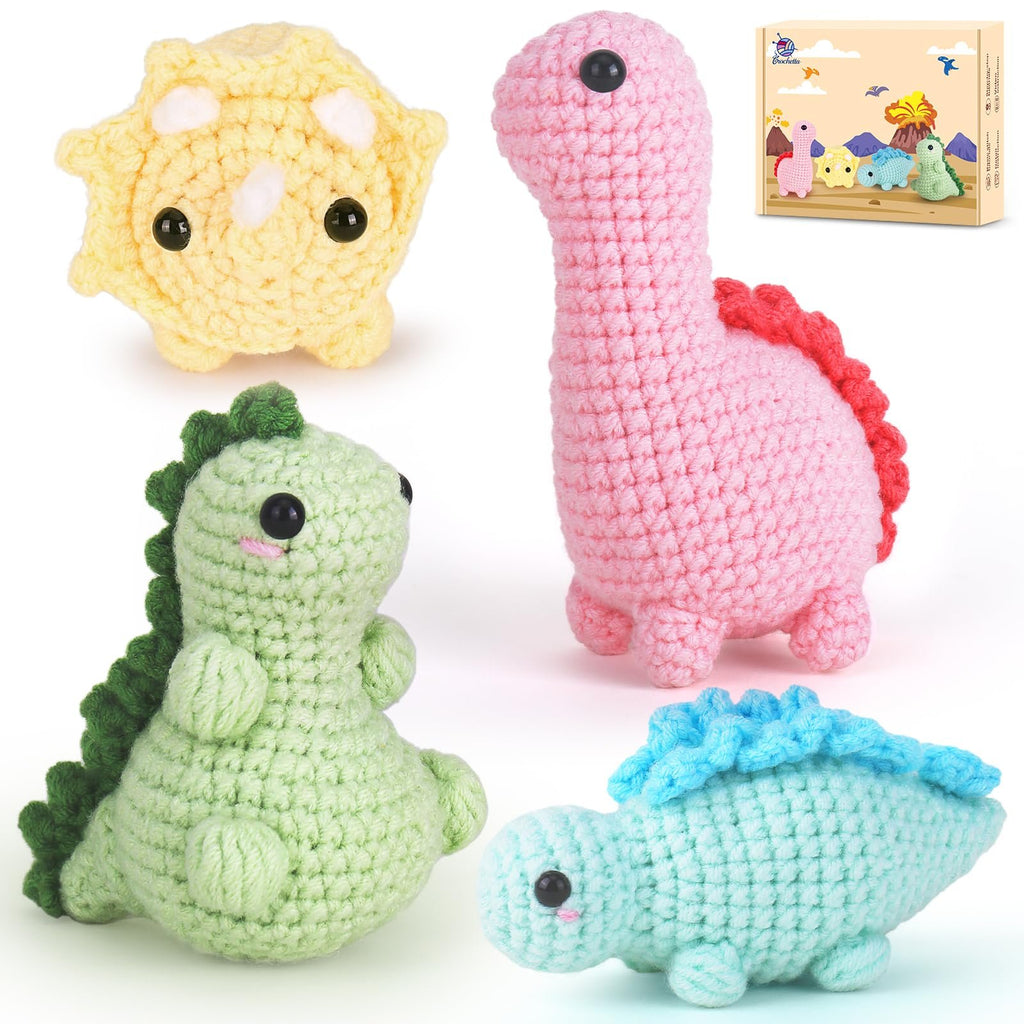 Four crocheted dinosaur toys in various colors, including pink, green, yellow, and blue, with a small box in the background showing illustrations of the toys.