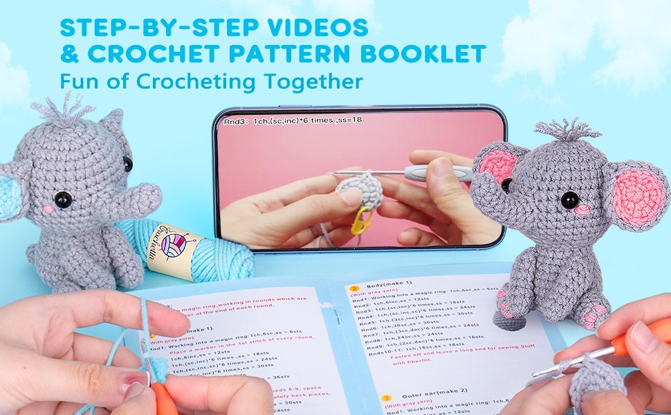 Crochet animal kit with two finished elephants, yarn, pattern booklet, and video tutorial on a phone screen.