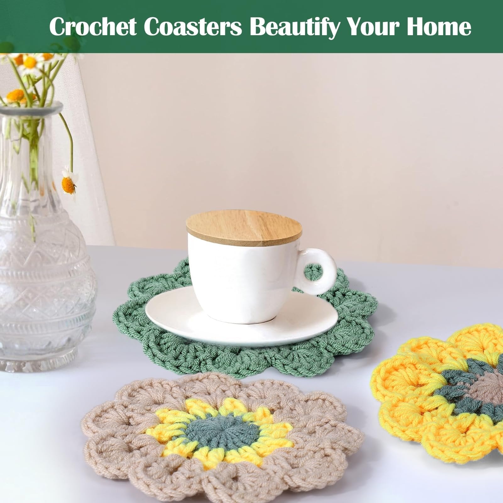 Three crocheted flower coasters with a cup and saucer on one, and a vase of flowers to the side.