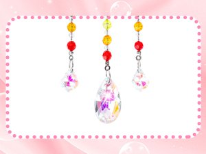 Three crystal suncatchers with colorful beads hanging against a pink and white background.