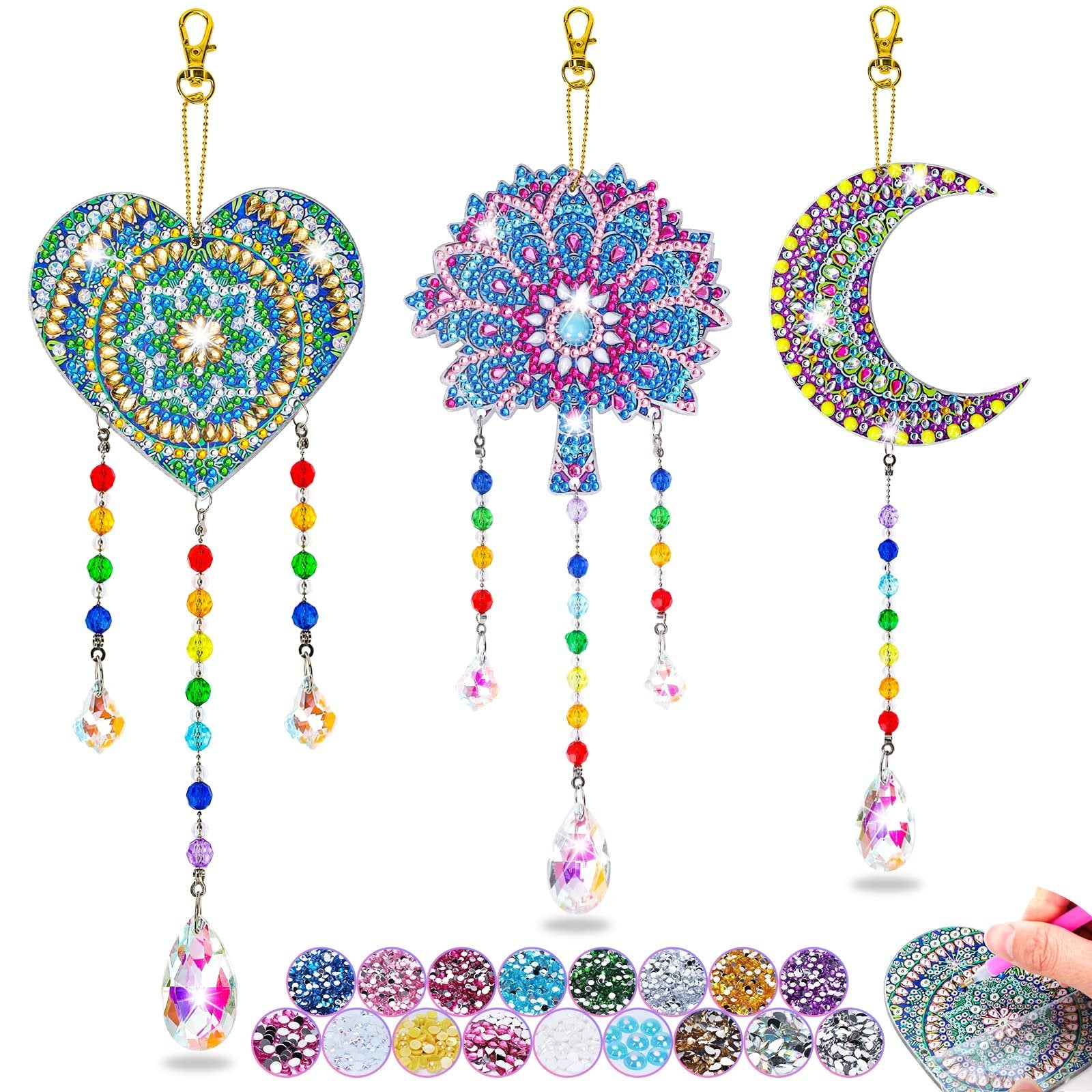 Diamond art wind chime kit with heart, tree, and moon shapes, plus gem samples and a hand applying gems.