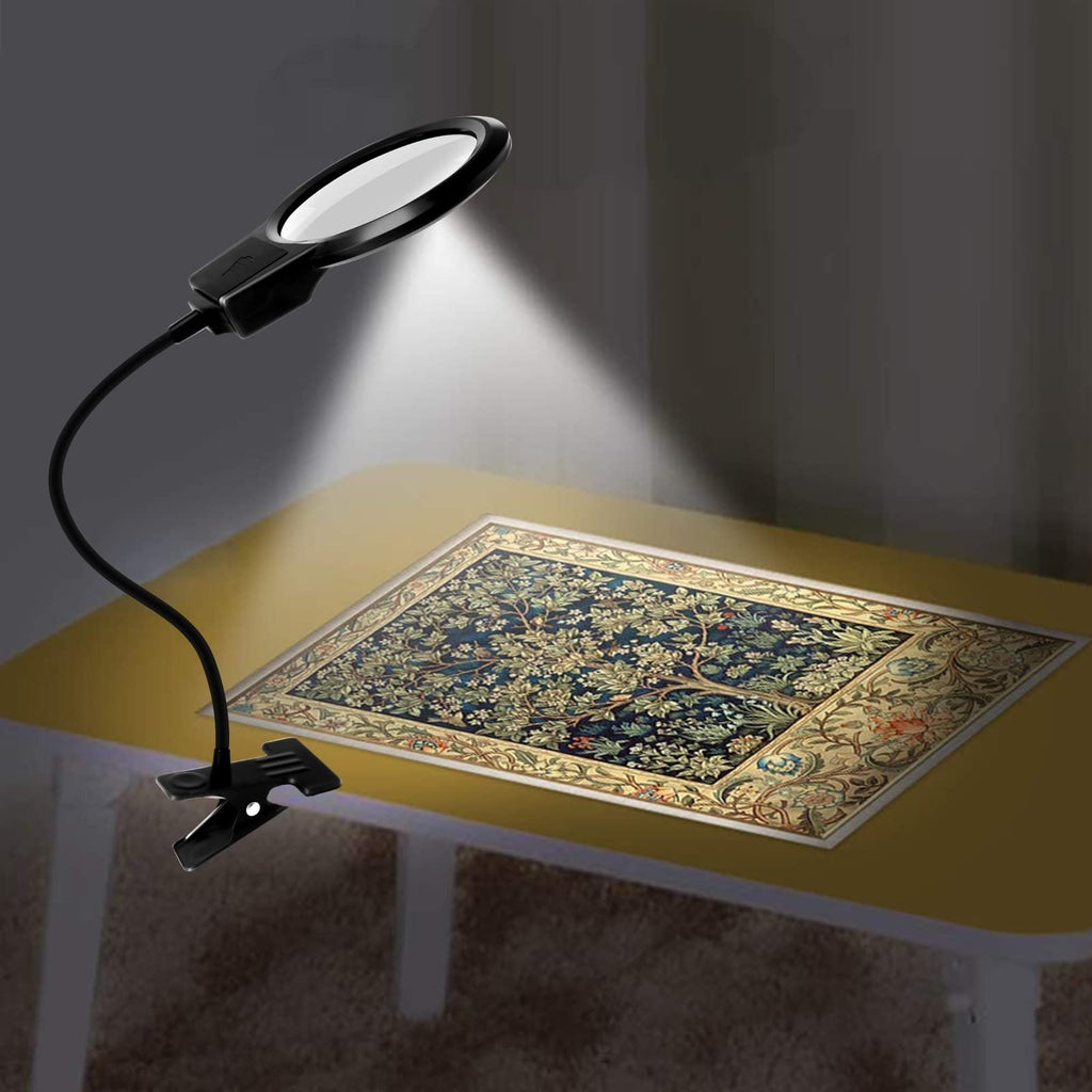 Black LED magnifier lamp with flexible gooseneck and clip attached to a table, illuminating a diamond painting.