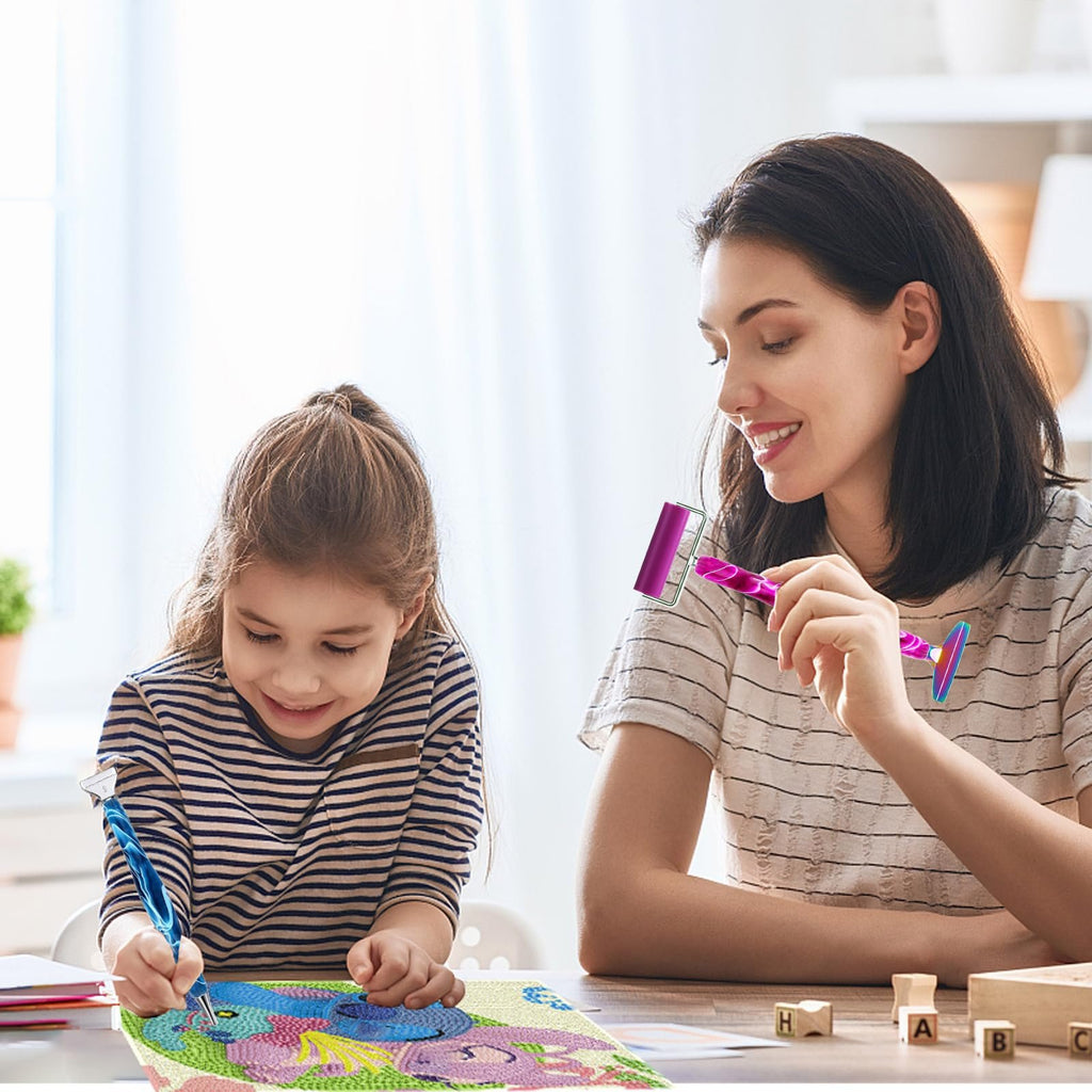 Mother and daughter doing diamond painting at a table, holding tools and smiling.