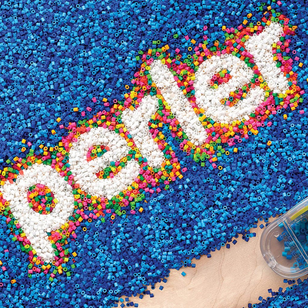 Fuse beads spelling out '' in white, surrounded by blue beads, with a clear bead container in the corner.