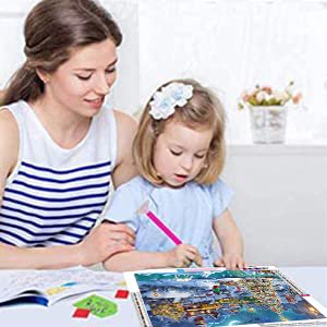 Mother and daughter doing a diamond painting kit at a table, with the finished painting in the foreground.