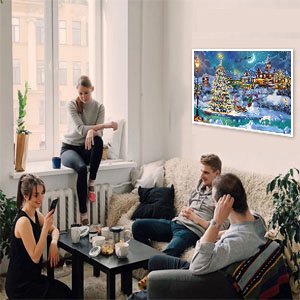 Group of friends relaxing in a living room with a diamond painting kit displayed on the wall