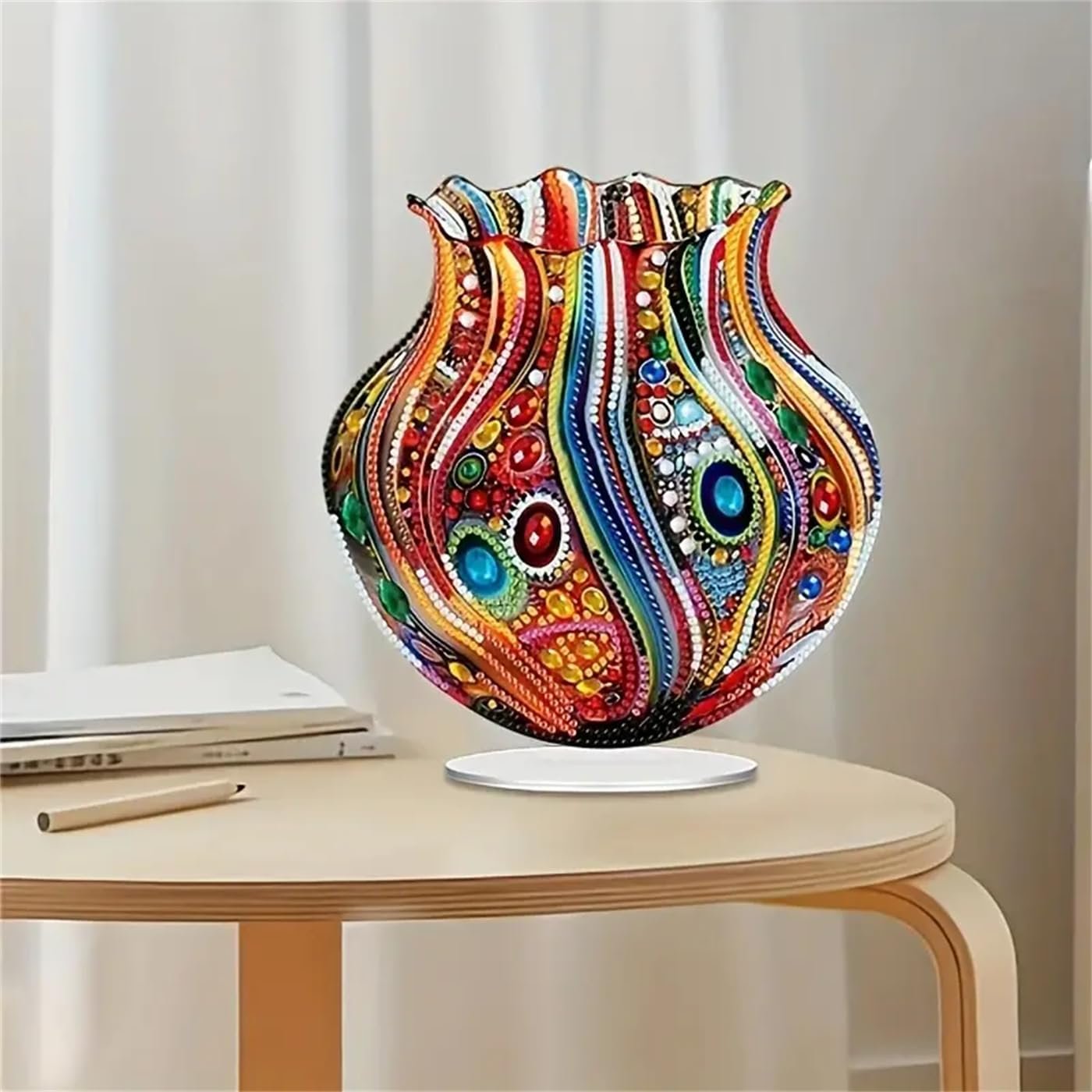 Colorful 5D diamond painting vase ornament on a wooden table with books and a pencil