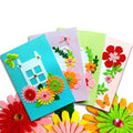 DIY card making kit with colorful felt flowers, butterflies, and house shapes on blank cards and envelopes.
