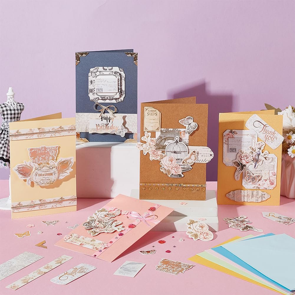 DIY card making kit with decorative papers, stickers, and finished cards displayed on a pink surface.
