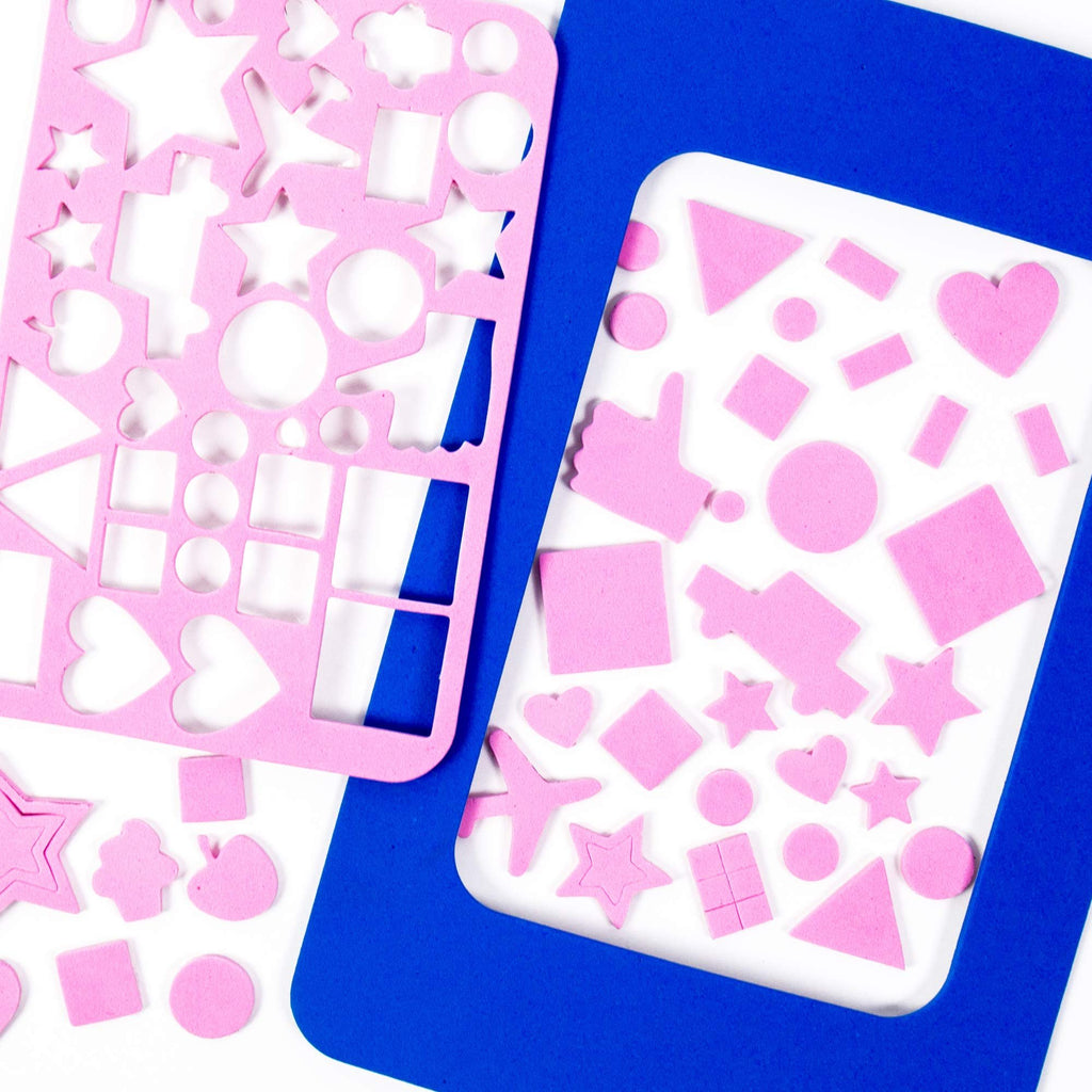 Pink foam shapes including stars, hearts, circles, squares, and a plane, scattered around a blue frame and a pink stencil sheet.