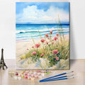 Paint by numbers kit with beach scene, pink flowers, and ocean waves, includes acrylic paints and brushes.