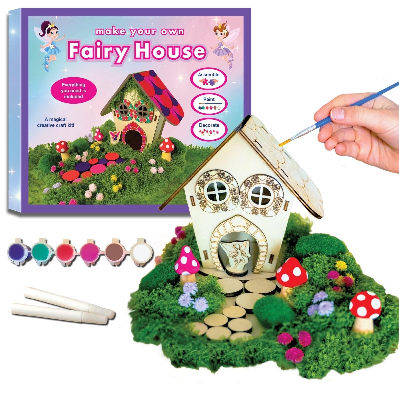 DIY wooden fairy house craft kit with paints, brush, moss, flowers, mushrooms, glue and base shown with box.