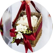 Wedding flower girl basket decorated with burgundy ribbon and white flowers
