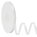 White satin ribbon on a spool with a wavy tail against a white background