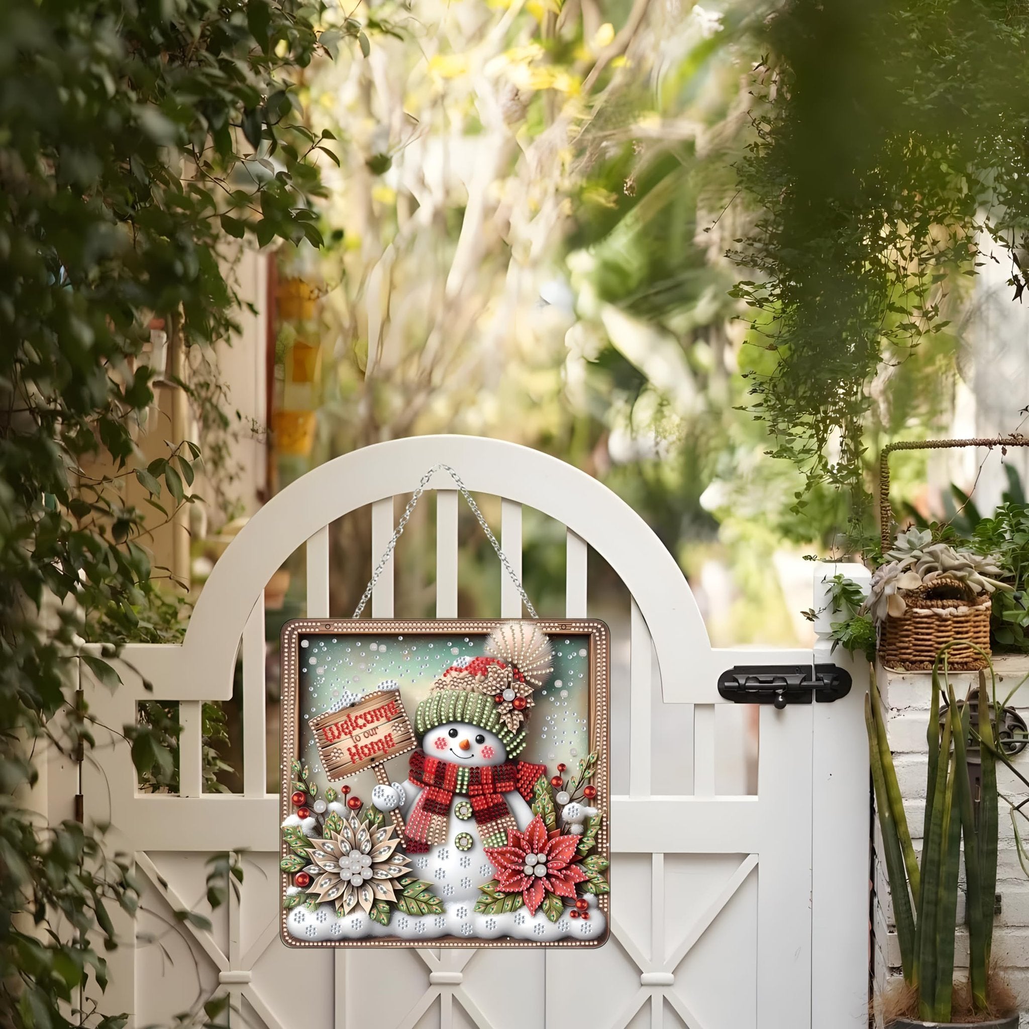 Diamond art snowman ornament hanging on a white gate, with a 'Welcome to our Home' sign.