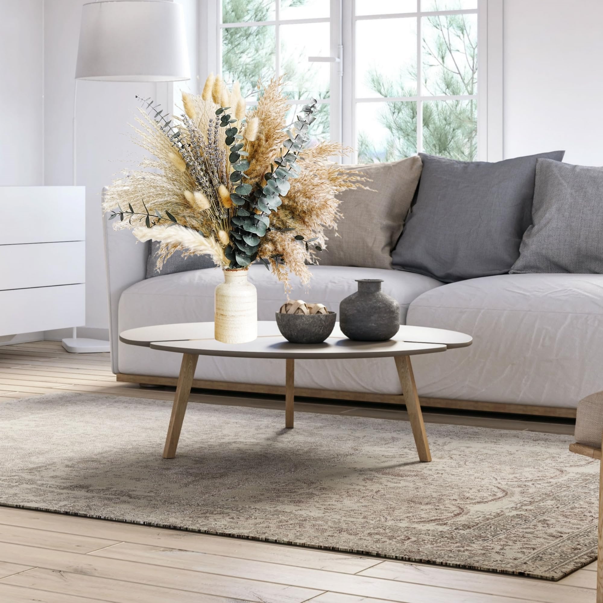 Boho dried flower bouquet with pampas grass and eucalyptus in a vase on a coffee table