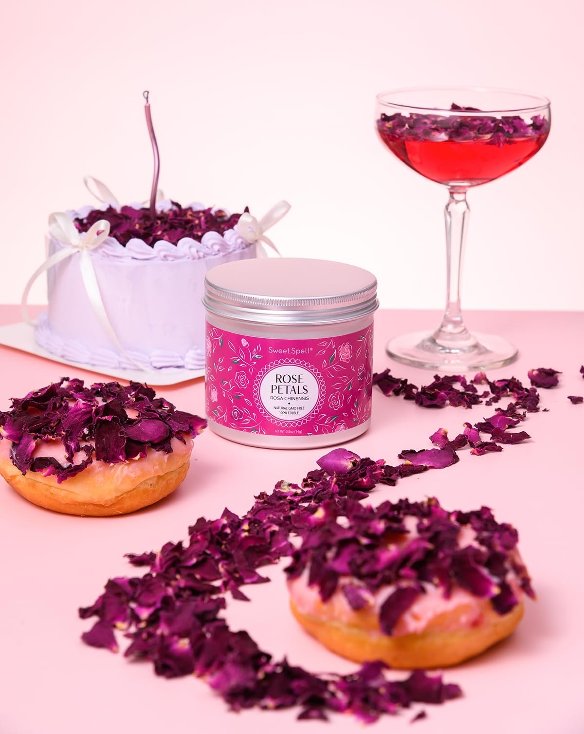 Dried rose petals decorating a cake, donuts, and a cocktail, with a jar of petals in the center.