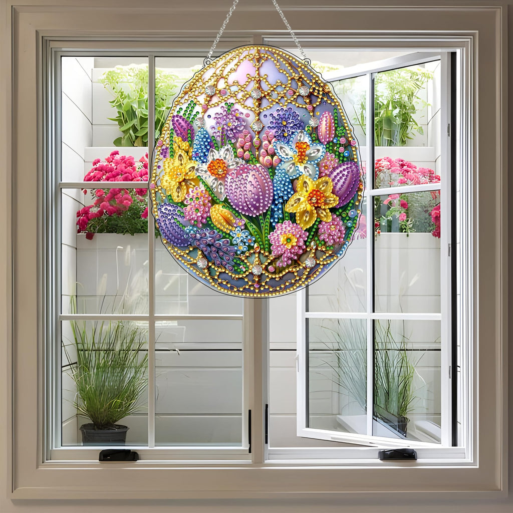 Easter egg shaped diamond art hanging kit with colorful flowers and rhinestones, displayed in a window with plants.