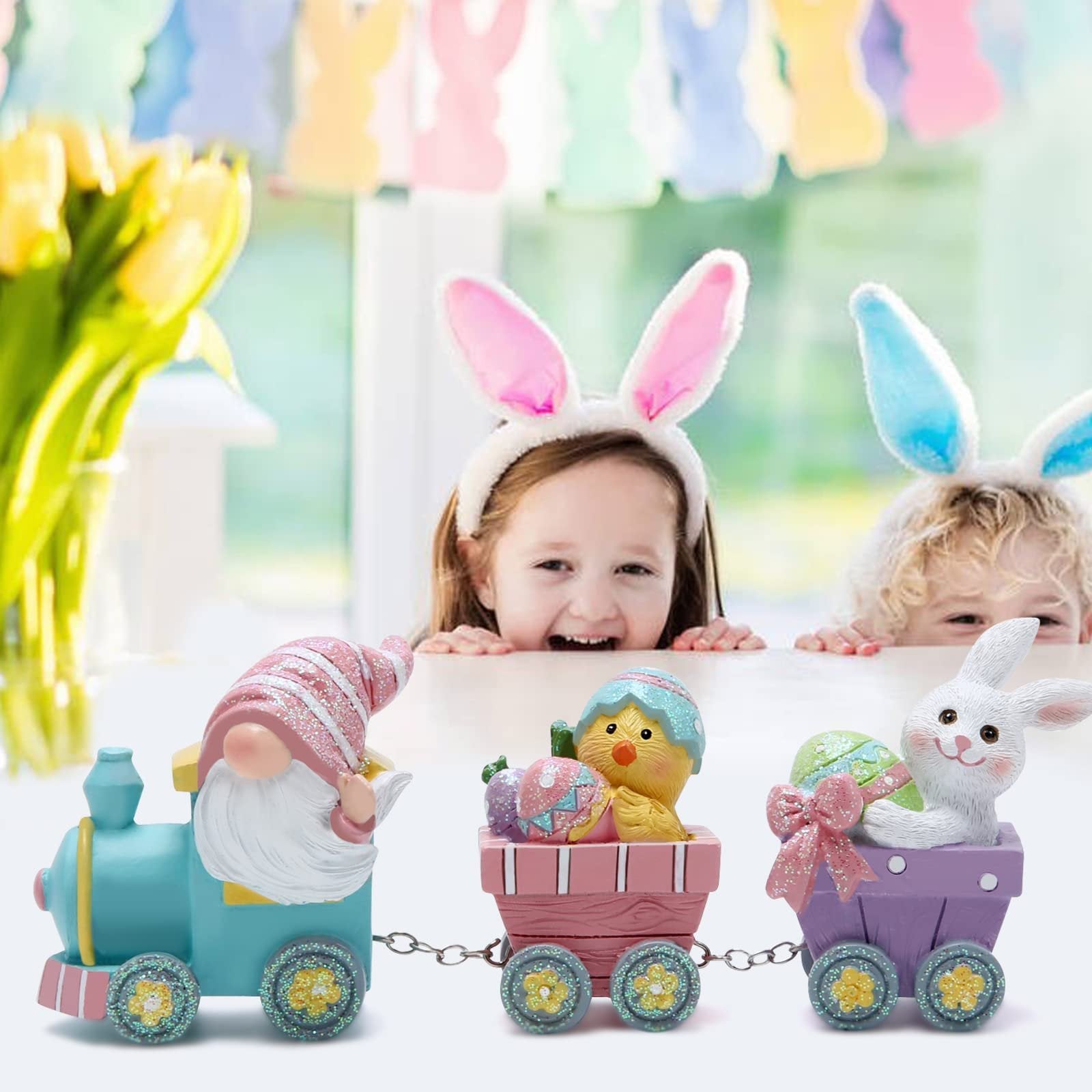 Easter train figurines with gnome, chick, and bunny in cars, with children wearing bunny ears in background.