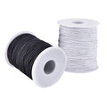 Two spools of elastic string, one black and one white, on white plastic spools against a white background.